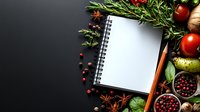Fresh ingredients and blank recipe notebook with herbs, spices, and vegetables arranged on dark background. Copy space for menu planning and cooking notes.