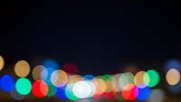 Colorful bokeh lights creating dreamy blur effect against dark background for festive holiday decorations and celebration atmosphere design projects.