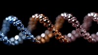 Spiral DNA molecule macro photography with blue, copper and pink metallic tones showing genetic structure in dark background. Scientific research concept.