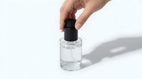 Close-up of hand applying clear nail polish or cosmetic liquid from glass bottle with black cap on white background for beauty and skincare projects.