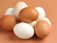 Fresh brown and white chicken eggs arranged on brown background, natural organic food composition showing variety in farm egg colors and textures.