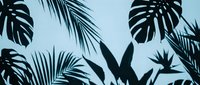 Tropical leaves silhouettes including monstera and palm on a light blue background, creating a bold exotic botanical pattern for modern design.