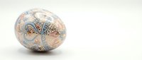Decorative ceramic egg with intricate folk art patterns and floral motifs on white background, isolated for design projects and cultural crafts.