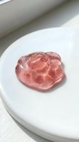 Pink gel slime with bubble texture on white ceramic plate, isolated against light background. Suitable for product photography, sensory toy marketing, and craft content.