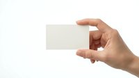 Hand holding blank white business card mockup isolated on white background for corporate identity and branding design projects.