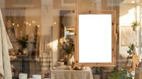 Wooden frame mockup on rustic wall with warm lighting, plants, and home decor. Blank space for design, branding, or artwork display in modern interior setting.