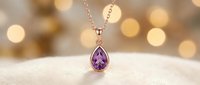 Amethyst teardrop pendant necklace with silver chain on soft fabric, warm bokeh background, luxury jewelry for special occasions.