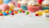 Blurred colorful cupcakes and candy background with copy space for party invitations, bakery promotions and sweet celebration designs.