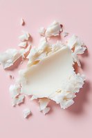 Torn white paper pieces creating abstract composition on pink background. Artistic flat lay with ripped edges and soft shadows for modern design projects.