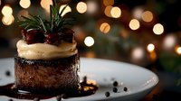 Decadent chocolate dessert with vanilla cream topping and fresh mint garnish on white plate against blurred golden bokeh lights, elegant restaurant presentation.