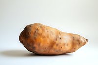 Fresh raw sweet potato on white background, organic root vegetable with natural texture and earthy color, isolated for food photography and culinary design.