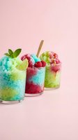 Colorful shaved ice drinks with layered fruit flavors, fresh berries, lime slices, mint garnish and wooden straws on pink background for summer beverage concepts.