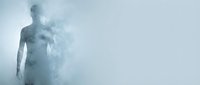 Young adult male figure dissolving into white smoke and mist against light background, representing transformation, disappearance, or abstract concepts for wellness and mindfulness projects.
