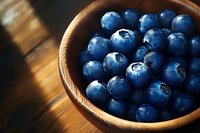 Fresh blueberries in wooden bowl on rustic table. Healthy organic superfood berries for breakfast, smoothies, baking and cooking recipes.
