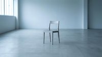 Modern transparent chair positioned in minimalist empty room with concrete floor and bright natural light, suitable for interior design, furniture catalogs, and contemporary space concepts.