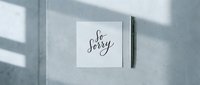 Handwritten so sorry card with a pen on a light concrete surface with soft shadows, conveying apology and sympathy for greeting card design.