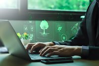 Businessman typing on laptop with green holographic eco-friendly icons displaying renewable energy, recycling, and sustainability concepts for business.