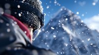 Young male skier wearing protective goggles and helmet against snowy mountain backdrop with flying snow particles creating dynamic winter sports atmosphere.