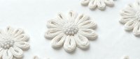 Delicate cream rope flowers with textured petals arranged on white background, isolated decorative elements for crafting and design projects.