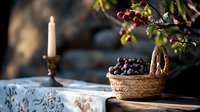 Fresh dark grapes in woven basket next to burning white candle in brass holder on rustic wooden surface, moody autumn still life composition.