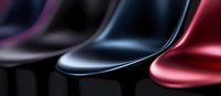 Modern chairs in black and metallic red colors arranged in row, showing smooth curved lines and glossy surfaces with selective focus and blurred background.