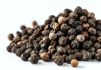 Whole black peppercorns pile on white background, aromatic spice ingredient for cooking and seasoning food in gourmet cuisine.