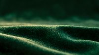 Close-up of dark green fabric texture with soft lighting highlighting woven fibers and natural folds, suitable for textile, fashion, and material design projects.