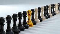 Golden chess king stands out among black and white pawns in strategic leadership concept for business success and competitive advantage.