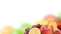 Fresh mixed fruits including orange slices, strawberries, grapes and peaches on bright colorful background for healthy eating and nutrition concepts.