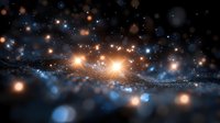Glowing cosmic particles and stars in deep space create mesmerizing light trail with orange and blue bokeh effect against dark background. Suitable for astronomy themes.
