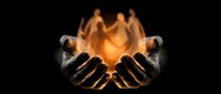 Hands cupped together holding glowing orange flame or light energy on black background for spiritual healing meditation concepts.