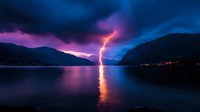 Lightning bolt strikes water between mountains during dramatic sunset, reflecting orange light on calm lake surface against purple and blue stormy sky.