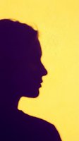 Silhouette of a woman in profile against a bright yellow background, suitable for psychology, mental health, wellness, and corporate branding projects.