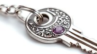 Ornate vintage style key pendant with purple amethyst stone and intricate floral pattern in silver metal finish on white background, isolated for jewelry design.