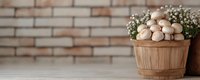 Fresh white mushrooms in rustic wooden basket with delicate baby's breath flowers against brick wall background, creating cozy farmhouse atmosphere.