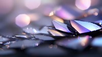 Shattered glass fragments with purple and pink bokeh light reflections creating abstract macro photography composition on dark background.