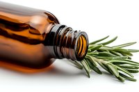 Fresh rosemary sprig next to amber glass essential oil bottle on white background, aromatherapy and natural wellness concept for spa and holistic health.