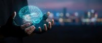 Businessman holding glowing digital brain hologram in hands representing artificial intelligence, machine learning and innovative technology solutions.
