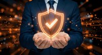 Professional businessman in dark suit holding glowing shield with checkmark symbol representing cybersecurity, data protection and business insurance solutions.