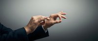 Professional businessman hands in elegant gesture reaching forward in dark suit against gradient background for corporate presentations.