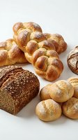 Assorted fresh baked breads including braided loaves, seeded whole grain, and round rolls dusted with flour on white background for bakery, food, and culinary use.