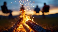 Silhouetted figures gather around a blazing campfire at dusk, with glowing embers and sparks flying upward against a warm sunset sky, perfect for outdoor recreation and social gathering concepts.