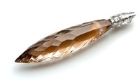 Elongated crystal gem with faceted surface in champagne color and silver cap on white background, luxury jewelry element isolated for design use.