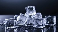 Clear ice cubes with water droplets on dark background, frozen crystal blocks with melting surface texture for beverage cooling and cocktail presentation.