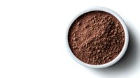 Ground cocoa powder in white ceramic bowl on white background, overhead view showing rich brown color and fine texture. Isolated with copy space.