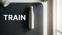 Stainless steel water bottle on dark mat with train text, fitness and hydration concept for gym, sports, wellness and healthy lifestyle design.