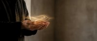 Businessman holding glowing energy spiral in cupped hands representing innovation, power, and digital transformation in corporate environment.