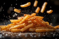 Golden french fries falling with salt crystals in motion against dark background, crispy potato sticks with seasoning in dramatic lighting for menu design.