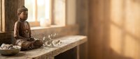 Bronze Buddha statue in meditation pose on wooden shelf with warm sunlight streaming through window creating peaceful zen atmosphere for mindfulness practice.