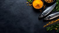 Fresh raw fish with aromatic spices and herbs on dark slate background for culinary cooking and healthy seafood meal preparation.